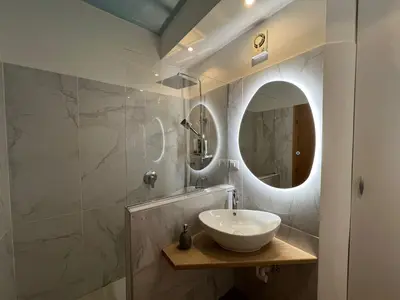 a bathroom with a sink and a mirror at Thermae Apartment in Merano