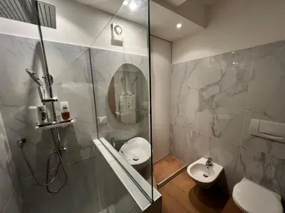 a bathroom with a shower and a toilet and a sink at Thermae Apartment in Merano