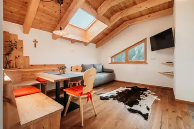 a living room with a table and a couch at Großkarnaiderhof Ferienwohnungen-Bauernhof-Dolomiten-Natur Pur in Luson