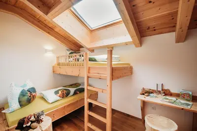 a room with two bunk beds and a window at Großkarnaiderhof Ferienwohnungen-Bauernhof-Dolomiten-Natur Pur in Luson