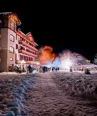 a group of people walking down a street at night at Chalet con vista villaggio ploner in Dobbiaco