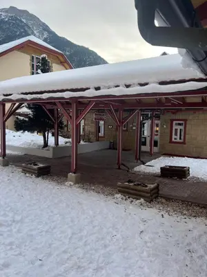 a snow covered pavilion in front of a building at Chalet con vista villaggio ploner in Dobbiaco