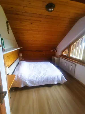a bedroom with a white bed in a attic at Chalet Genziana in Cavalese