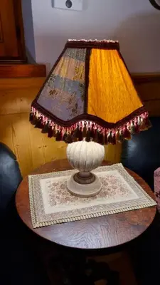 a table with a lamp on top of a table at Chalet Genziana in Cavalese