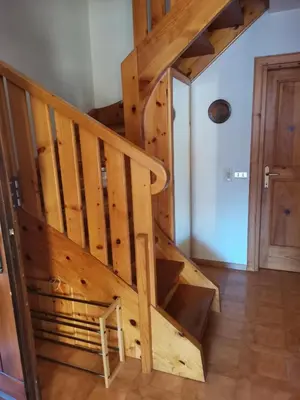 a wooden staircase in a room with a door at Chalet Genziana in Cavalese