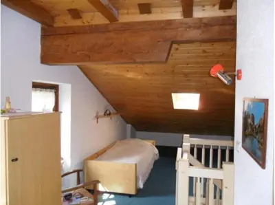 a bedroom with a bed and a wooden ceiling at Moena Appartamento Fior di Melo con WiFi e Riscaldamento in Moena