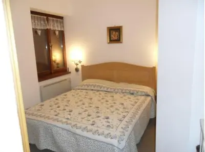 a bedroom with a bed in a room with a window at Moena Appartamento Fior di Melo con WiFi e Riscaldamento in Moena