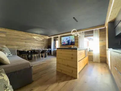 a bedroom with a bed and a dining room at Duo Charme in Moena