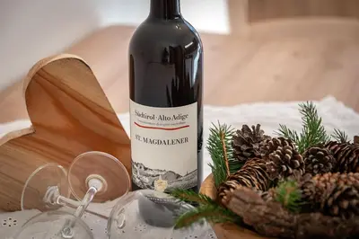 a bottle of wine sitting on a table with pine cones at Austillerhof - Urlaub auf dem Bauernhof in Funes