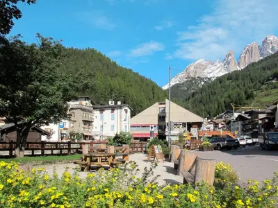 a town in the mountains with tables and flowers at Apartment Casa Costazzer A by Interhome in Mazzin