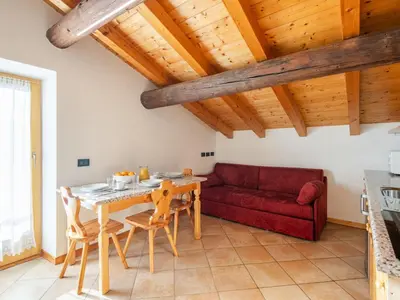 a living room with a table and a red couch at Apartment Casa Costazzer A by Interhome in Mazzin