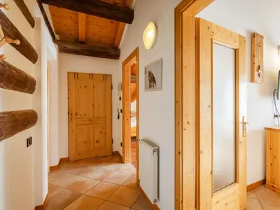 a hallway with wooden ceilings and a door at Apartment Casa Costazzer A by Interhome in Mazzin