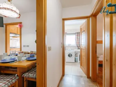 a kitchen and dining room with a table and a laundry room at Apartment Fontanelle-3 by Interhome in Alba di Canazei