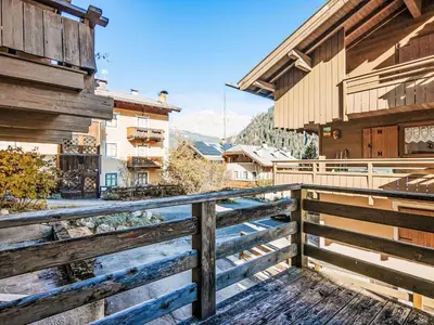 a balcony with a wooden fence and buildings at Apartment Fontanelle-3 by Interhome in Alba di Canazei