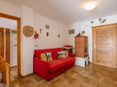 a red couch sitting in a living room at Apartment Fontanelle-3 by Interhome in Alba di Canazei