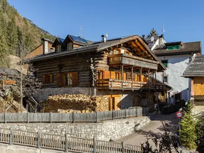 a large wooden house with a fence in front of it at Apartment Casa Costazzer B by Interhome in Mazzin