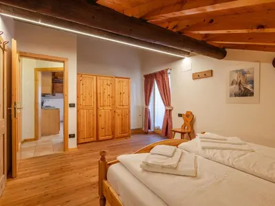 a bedroom with a bed and wooden floors at Apartment Casa Costazzer B by Interhome in Mazzin