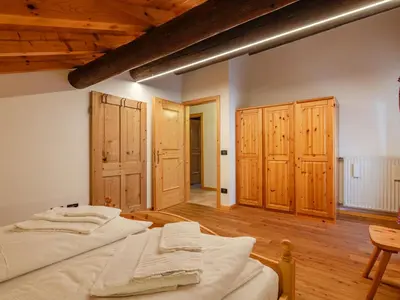 a bedroom with two beds and wooden cabinets at Apartment Casa Costazzer B by Interhome in Mazzin