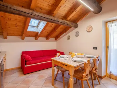 a living room with a red couch and a table at Apartment Casa Costazzer B by Interhome in Mazzin