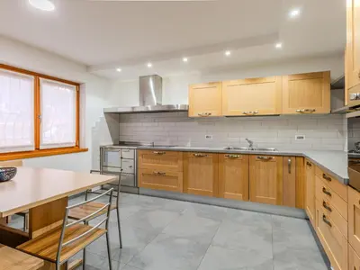 a kitchen with wooden cabinets and stainless steel appliances at Apartment Elisa by Interhome in Ronzone