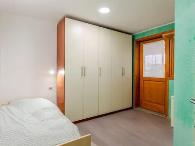 a bedroom with a bed and a green wall at Apartment Elisa by Interhome in Ronzone