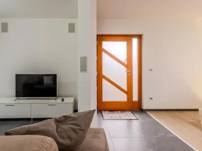 a living room with a door and a television at Apartment Elisa by Interhome in Ronzone
