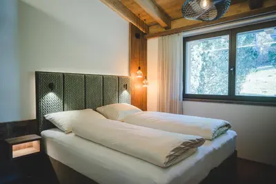 two beds in a room with a window at Der Hof - Perntal Retreat in Gais