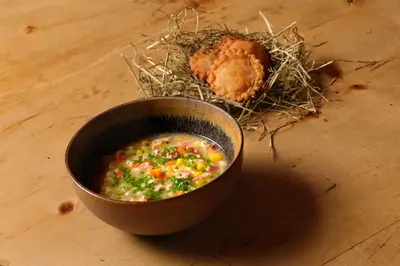 a bowl of soup and a bird nest on a table at Der Hof - Perntal Retreat in Gais