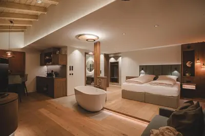 a bedroom with a bed and a bath tub at Der Hof - Perntal Retreat in Gais