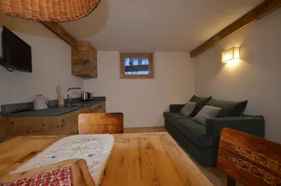 a living room with a green couch and a table at Dolomiti charme in Cortina dʼAmpezzo