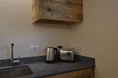 a kitchen with a counter top with a sink and a coffee maker at Dolomiti charme in Cortina dʼAmpezzo