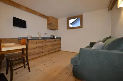 a living room with a couch and a table at Dolomiti charme in Cortina dʼAmpezzo
