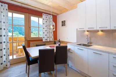 a kitchen with a table and chairs and a window at Wibmerhof in Tesido