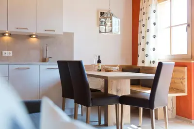 a kitchen with a wooden table and black chairs at Wibmerhof in Tesido