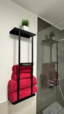 a towel rack with red towels in a bathroom at Apartment Rohrer - Zirm - Zirbe Cirmolo mit Schloss- und Schourtblick in Sarntal