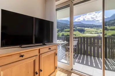 a living room with a large flat screen tv on a dresser at Apartment Rohrer - Zirm - Zirbe Cirmolo mit Schloss- und Schourtblick in Sarntal
