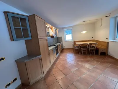 a kitchen and dining room with a table in it at Cèsa Sot Bosch in Canazei
