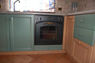 a kitchen with an oven in a kitchen at Cèsa Sot Bosch in Canazei