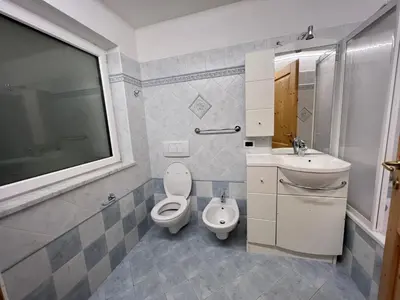 a bathroom with a toilet and a sink at Cèsa Sot Bosch in Canazei