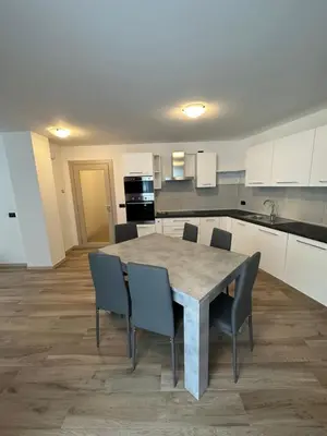 a kitchen with a table and chairs in a room at Cèsa Sot Bosch in Canazei