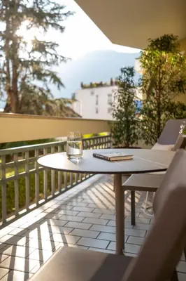 a table and chairs on a balcony with a view at Avista Apartments Terme in Merano
