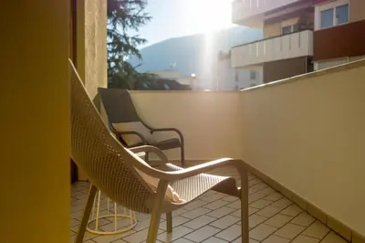 two chairs sitting on the balcony of a building at Avista Apartments Terme in Merano