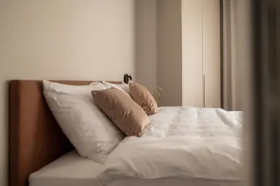 a bed with white sheets and pillows on it at Avista Apartments Terme in Merano