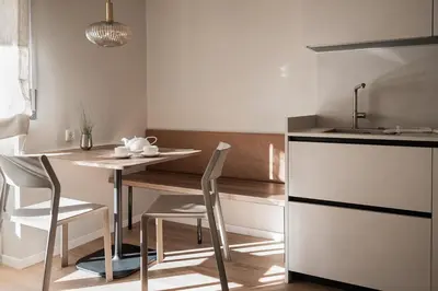 a kitchen with a table and chairs and a sink at Avista Apartments Terme in Merano
