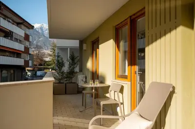 a patio with chairs and a table on a balcony at Avista Apartments Terme in Merano