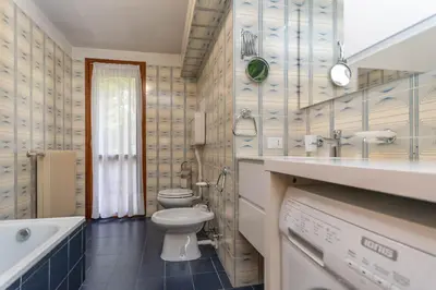 a bathroom with a toilet and a sink and a tub at Le Ginestre in Alleghe