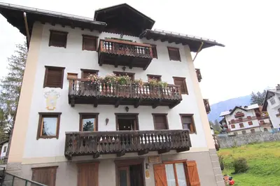 a building with balconies and flowers on it at Chalet Ampezzano di Marisa in Cortina dʼAmpezzo