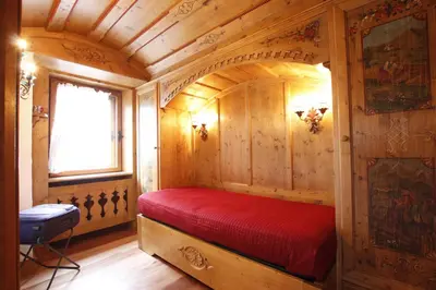 a bedroom with a red bed in a wooden room at Chalet Ampezzano di Marisa in Cortina dʼAmpezzo