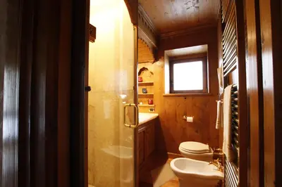 a bathroom with a toilet and a sink and a window at Chalet Ampezzano di Marisa in Cortina dʼAmpezzo