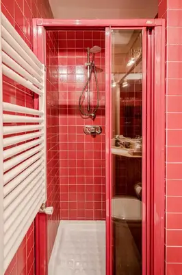 a red tiled bathroom with a shower and a sink at Dolce Casa Cortina Centro-Ski in Cortina dʼAmpezzo